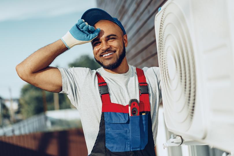 An HVAC technician servicing an air conditioning unit
